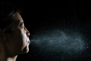 Woman coughing or sneezing. Concept of spread of the virus. Spray infection