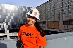 Nancy, a laborer, waring a LiUNA t-shirt and a hard hat with a LiUNA sticker