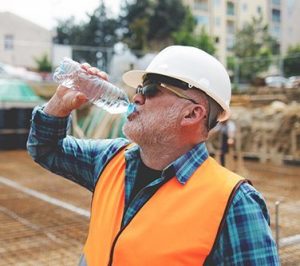 Laborer drinking water to stay hydrated on jobsite